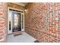 Welcoming front entryway with brick accents and a black door with sidelights at 1955 Overlook Run Pl, Cumming, GA 30040