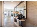 Inviting hallway showcasing modern console table and mirror, leading to a bright living area with outdoor access at 4720 Montane St, Cumming, GA 30028