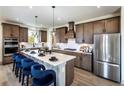 Modern kitchen with stainless steel appliances, a large island with bar seating, and stylish pendant lighting at 4720 Montane St, Cumming, GA 30028