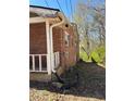 Exterior view of a brick home showing the side with exposed pipes and possible foundation issues at 5317 Kings Hwy, Douglasville, GA 30135