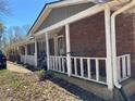 Covered porch with white railing featuring brick foundation and view of the front yard at 5317 Kings Hwy, Douglasville, GA 30135
