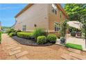The backyard features a stone paver walkway, lovely shrubs and garden beds at 5613 Lancashire Ln, Cumming, GA 30041