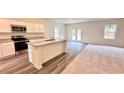 Open kitchen with granite countertops, stainless steel appliances, and views of the living area at 60 Sonoma Drive, Dallas, GA 30157