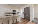 Bright kitchen featuring stainless steel appliances, granite counters, island with seating and hardwood floors at 60 Sonoma Drive, Dallas, GA 30157