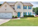 Charming two-story home boasts a well-manicured lawn, bright blue door, and matching shutters at 2995 Belshire Trl, Dacula, GA 30019
