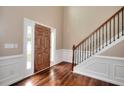 Inviting foyer features hardwood floors, a staircase with decorative iron balusters, and wainscoting at 2995 Belshire Trl, Dacula, GA 30019