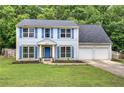 Beautiful two-story home with light blue siding, blue shutters, a well-manicured lawn and two car garage at 4975 Rockstone Way, Acworth, GA 30101