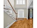 Bright foyer with hardwood floors, staircase, and front door with transom window at 125 Legacy Way, Oxford, GA 30054