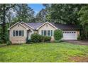 Charming home with manicured landscaping, green shutters, and an attached two-car garage at 273 Apalachee Church Rd, Auburn, GA 30011