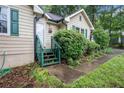 View of front door with green trim and small porch; adjacent landscape at 273 Apalachee Church Rd, Auburn, GA 30011