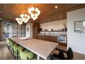 Bright dining area featuring a long table, modern lighting, wood floors and a modern kitchen, perfect for gatherings at 675 Drewry Ne St # 205, Atlanta, GA 30306
