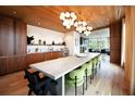 Spacious dining room featuring a long table, modern lighting, wood floors and wood ceiling, perfect for entertaining guests at 675 Drewry Ne St # 205, Atlanta, GA 30306