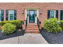 Inviting front entrance with manicured landscaping, brick steps, and a stylish glass-paneled door at 225 Carriage Station Cir, Roswell, GA 30075