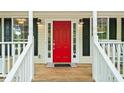 Inviting front porch with a bright red door, black shutters, and white railings at 701 Robert Ln, Canton, GA 30114