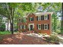 Traditional brick home featuring black shutters, mature trees and landscaping offering serene curb appeal at 2863 Landing Dr, Marietta, GA 30066