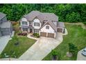 Aerial view of the spacious home featuring lush green lawn and a three car garage at 4241 Summer Breeze Way, Buford, GA 30518