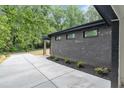 Side view of home exterior, showcasing brickwork, windows, landscaping, and a concrete driveway at 998 Lookout Nw Ave, Atlanta, GA 30318