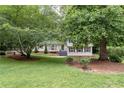 Beautifully landscaped front yard featuring mature trees, lush greenery, and a classic two-story home with gray shutters at 2786 Georgian Ter, Marietta, GA 30068