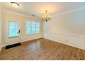 Bright dining room featuring hardwood floors, wainscoting, and an elegant chandelier at 750 Summerstone Ln, Lawrenceville, GA 30044