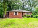 Traditional brick home with a well-maintained lawn and verdant landscaping, creating a welcoming atmosphere at 1913 Flintwood Se Dr, Atlanta, GA 30316