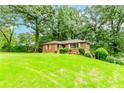 Quaint brick house nestled on a grassy hill, surrounded by mature trees offering privacy and a serene setting at 1913 Flintwood Se Dr, Atlanta, GA 30316