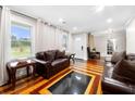 Cozy living room features hardwood floors, recessed lighting, large windows, and dark leather couches at 2021 Sherwood Dr Se, Marietta, GA 30062