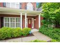 Close-up of a brick home's entrance, featuring a red door and well-kept landscaping at 3522 Estates Landing Nw Dr, Kennesaw, GA 30144