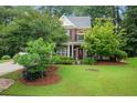 Attractive brick home with a well-manicured lawn and mature trees providing shade at 3522 Estates Landing Nw Dr, Kennesaw, GA 30144