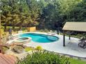 Backyard oasis features a sparkling pool, hot tub, and covered patio, perfect for relaxation and entertaining at 209 Breckenridge Ct, Canton, GA 30115