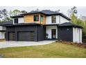 Modern home featuring a three-car garage, black brick accents and manicured lawn at 2551 Kilgore Rd, Buford, GA 30519