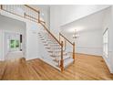 Bright foyer with wood floors, staircase with white railings, and view into the dining area at 5190 Beech Forest Sw Dr, Lilburn, GA 30047