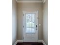 Clean entryway featuring a white door with window, neutral walls, and dark wood floors at 2317 Church Street, Hampton, GA 30228