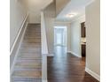 Inviting hallway with a staircase, hardwood floors, and bright, neutral paint at 2317 Church Street, Hampton, GA 30228