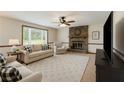 Bright living room with stone fireplace, neutral walls and carpet, a ceiling fan, and large window at 319 Hill Crest Cir, Woodstock, GA 30188