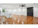 Open-concept living room with gleaming hardwood floors, a modern fireplace, and recessed lighting at 3455 Broxton Mill Way, Snellville, GA 30039