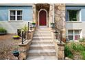 Close-up of home's front entrance with stone facade, stairs, black railings and a red door at 64 Edwin Nw, Atlanta, GA 30318