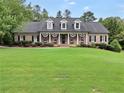 Inviting brick home with a lush green lawn, dormer windows, and rocking chairs on the front porch at 704 Branchview Ct, Mcdonough, GA 30252