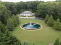 Expansive estate featuring a grand home, circular water fountain, surrounded by lush greenery at 1822 Chartwell Trce, Stone Mountain, GA 30087