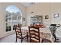 Bright dining area with large arched window, beige walls, and neutral carpet at 3834 Hawk Tail Dr, Loganville, GA 30052