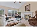 Comfortable living room featuring a decorative fireplace, ceiling fan, and sliding doors leading to the backyard at 3834 Hawk Tail Dr, Loganville, GA 30052