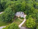 Aerial view of a brick home surrounded by lush greenery and mature trees at 320 Yellowroot Ln, Sandy Springs, GA 30350