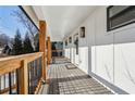 Covered front porch with wood decking, black railings, and modern wall mounted lighting at 3939 Hamilton Mill Rd, Buford, GA 30519