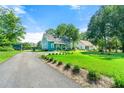 View of the home with a long driveway, lush lawn, and a detached garage at 5150 Wheat Ne St, Covington, GA 30014