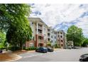 Apartment building with parking area and mature trees at 1965 Nocturne Dr # 1306A, Alpharetta, GA 30009