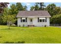 Welcoming single-Gathering home with a lush lawn, a driveway, and white siding that exudes a classic appeal at 8185 Rivertown Rd, Fairburn, GA 30213