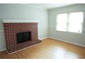 Bright living room featuring hardwood floors and a cozy brick fireplace at 936 Glynn Oaks Dr, Clarkston, GA 30021