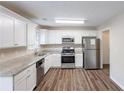Spacious kitchen featuring stainless steel appliances, granite countertops, white cabinets, and hardwood floors at 6590 Smoke Ridge Dr, Atlanta, GA 30349