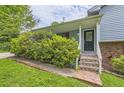 Inviting front porch with brick stairs, green shrubs, and a covered entrance with glass door at 3551 Cindy Way, Rex, GA 30273