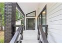 Inviting covered front porch with brick column and painted wood deck at 6700 Knollwood Cir, Douglasville, GA 30135