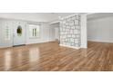 Bright open-concept living room featuring hardwood floors and a decorative stone column at 6802 Ida St, Lithonia, GA 30058